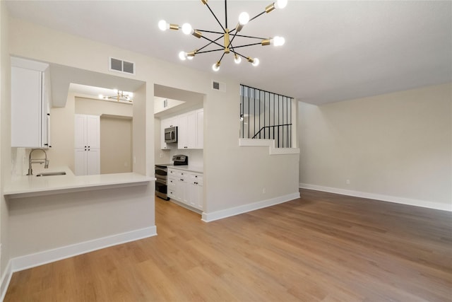 kitchen featuring white cabinetry, sink, stainless steel appliances, and light hardwood / wood-style floors