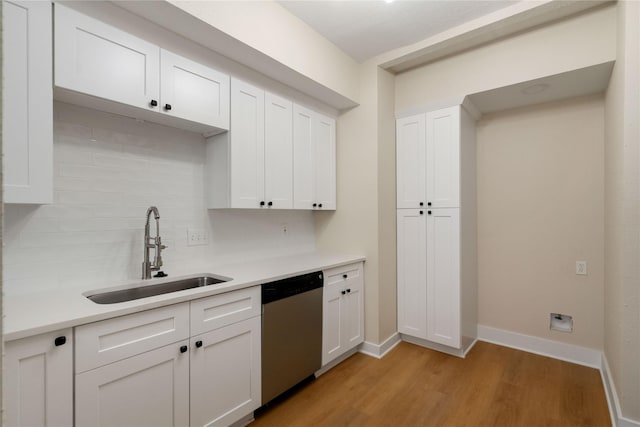 kitchen featuring dishwasher, white cabinetry, light hardwood / wood-style flooring, and sink