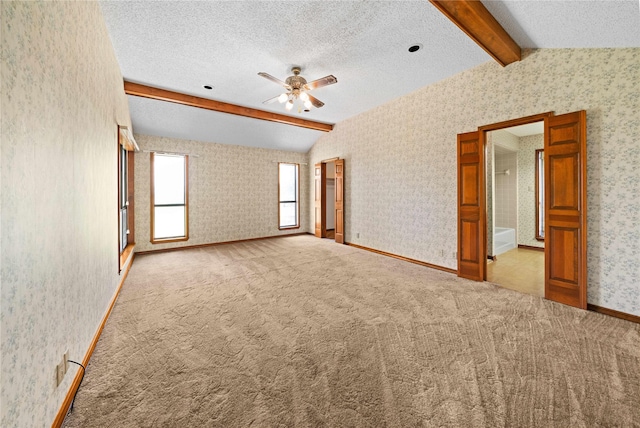 spare room with lofted ceiling with beams, ceiling fan, and light colored carpet