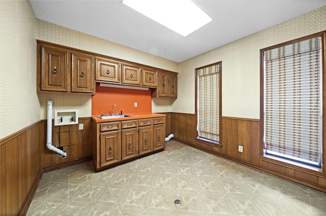 kitchen featuring wood walls and sink