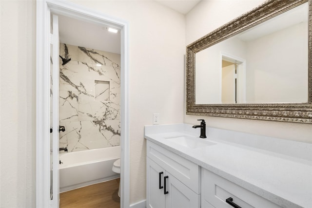 full bathroom featuring toilet, vanity, tiled shower / bath combo, and hardwood / wood-style flooring