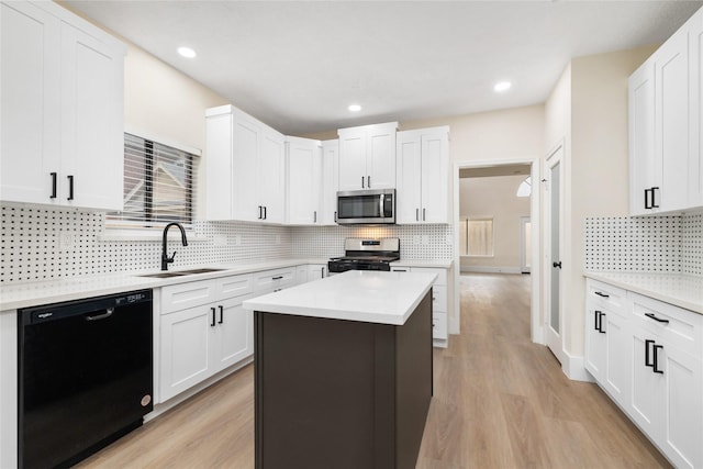 kitchen with sink, a center island, stainless steel appliances, decorative backsplash, and white cabinets