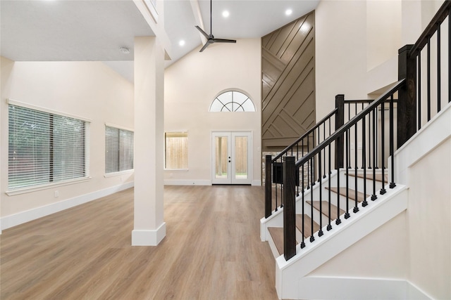 foyer with ceiling fan, plenty of natural light, high vaulted ceiling, and light hardwood / wood-style flooring