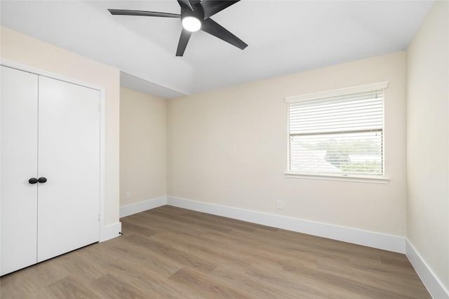 unfurnished bedroom featuring ceiling fan, light wood-type flooring, and a closet