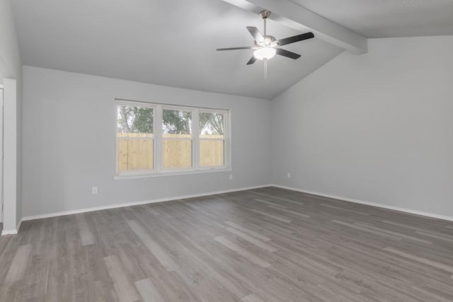 empty room featuring ceiling fan, hardwood / wood-style flooring, and lofted ceiling with beams