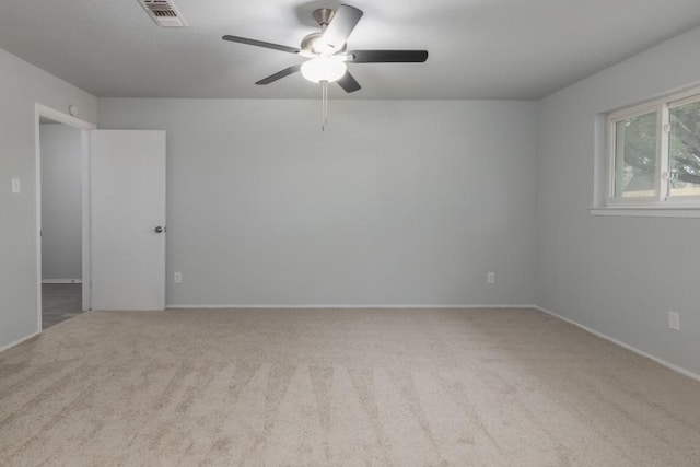 carpeted spare room featuring ceiling fan