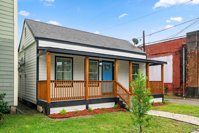 view of front of home featuring covered porch and a front lawn