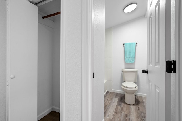 bathroom with bathtub / shower combination, wood finished floors, toilet, and baseboards