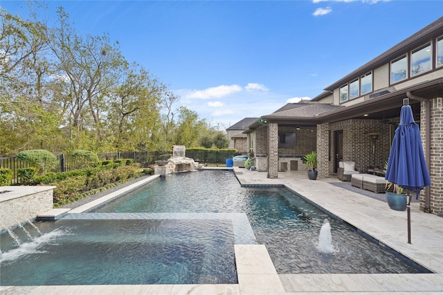 view of swimming pool with pool water feature and a patio