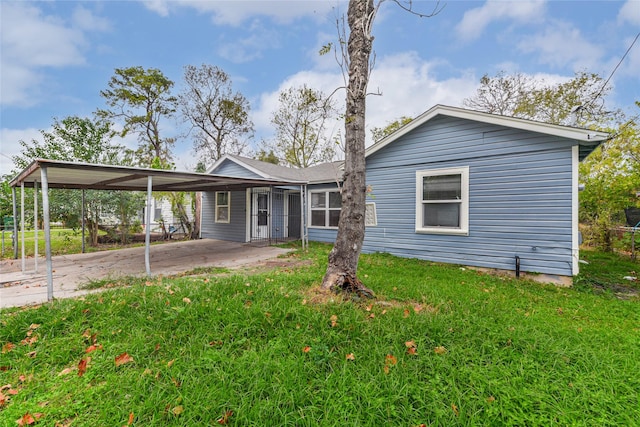 rear view of property featuring a carport and a yard