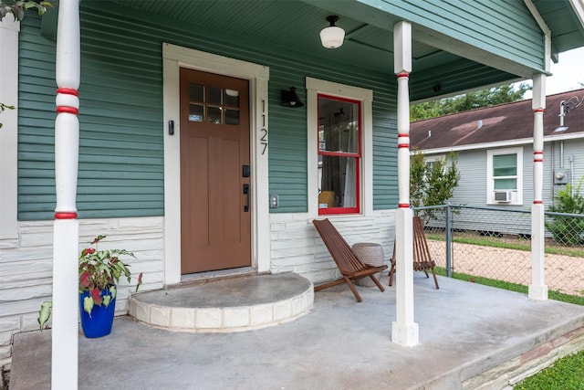 doorway to property featuring cooling unit and covered porch