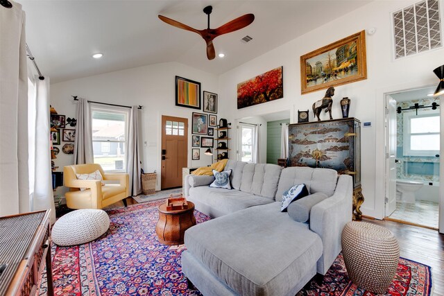 living room with ceiling fan, hardwood / wood-style floors, and lofted ceiling