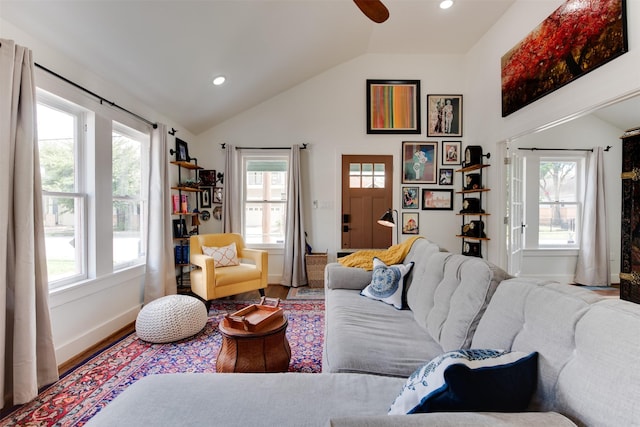 living room featuring light hardwood / wood-style flooring, vaulted ceiling, and ceiling fan