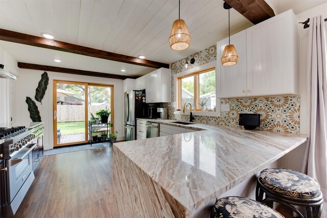 kitchen featuring white cabinets, a healthy amount of sunlight, and stainless steel appliances