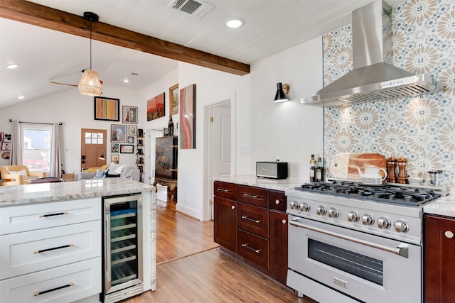 kitchen with high end range, lofted ceiling with beams, wall chimney range hood, wine cooler, and light hardwood / wood-style flooring