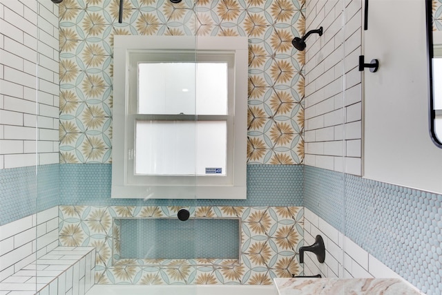 bathroom featuring tiled shower and tile walls