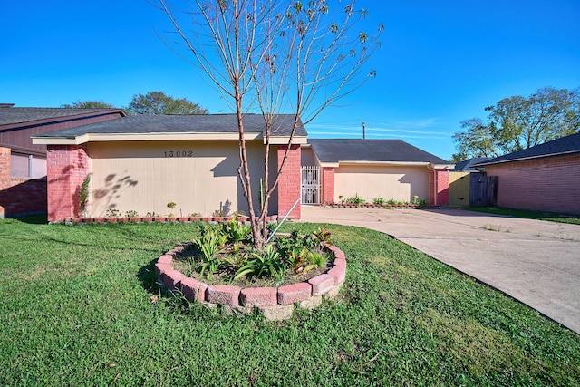 ranch-style house featuring a front yard and a garage