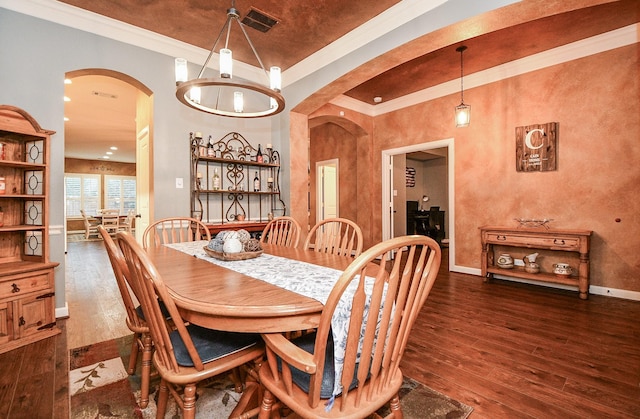 dining space featuring crown molding, dark wood-type flooring, and a notable chandelier