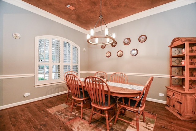 dining area featuring crown molding, dark hardwood / wood-style flooring, and an inviting chandelier