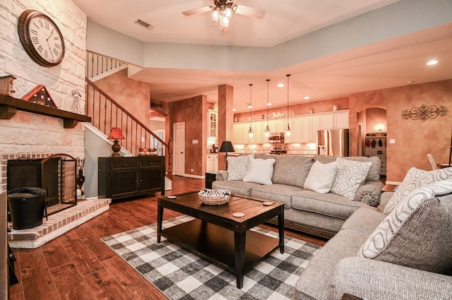 living room with ceiling fan, a fireplace, and dark hardwood / wood-style floors