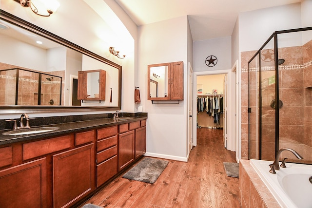 bathroom featuring shower with separate bathtub, vanity, and wood-type flooring