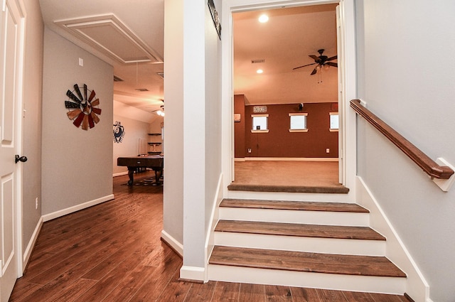 stairway with ceiling fan, wood-type flooring, and lofted ceiling