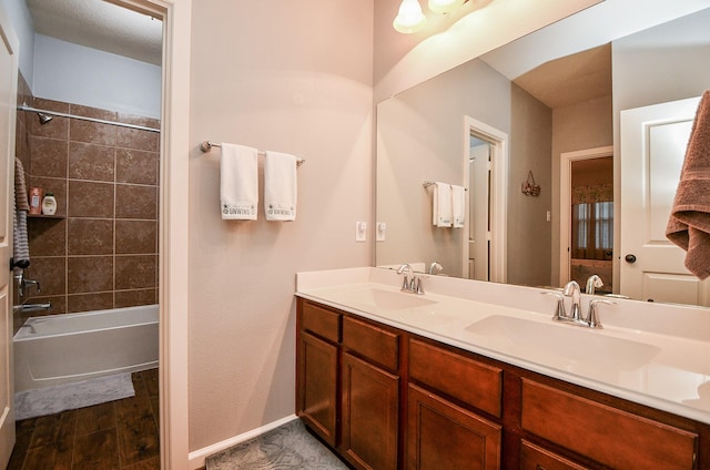 bathroom with vanity, wood-type flooring, and tiled shower / bath combo