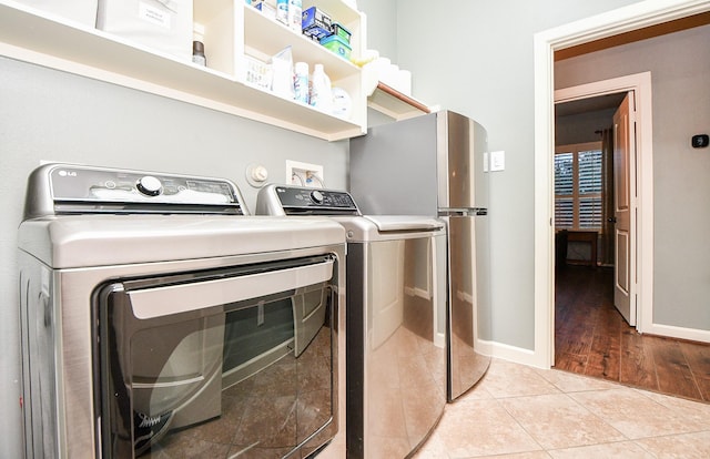 laundry area featuring washer and clothes dryer and light hardwood / wood-style floors