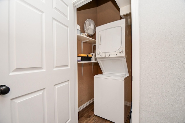 laundry room with dark hardwood / wood-style flooring and stacked washing maching and dryer