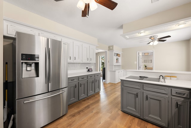 kitchen with decorative backsplash, gray cabinets, stainless steel fridge, light wood-type flooring, and white cabinetry