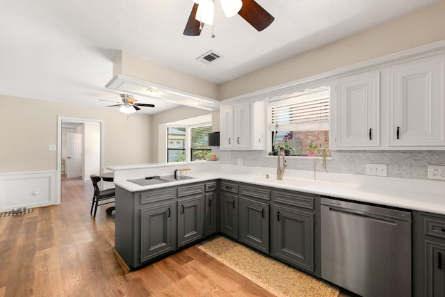 kitchen featuring kitchen peninsula, stainless steel dishwasher, black electric cooktop, sink, and light hardwood / wood-style flooring