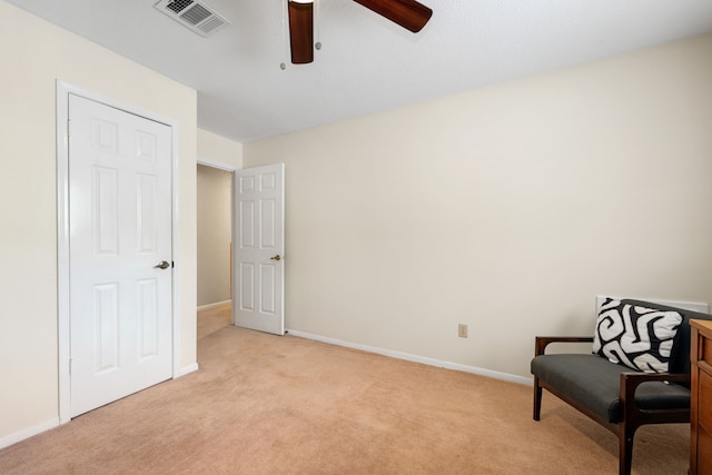 sitting room featuring ceiling fan and light colored carpet