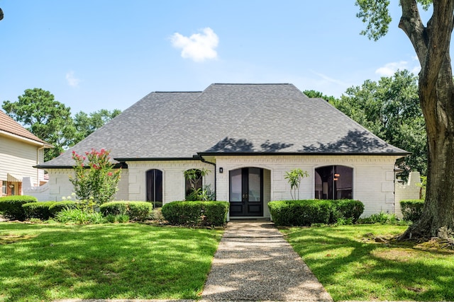 french provincial home with french doors and a front lawn