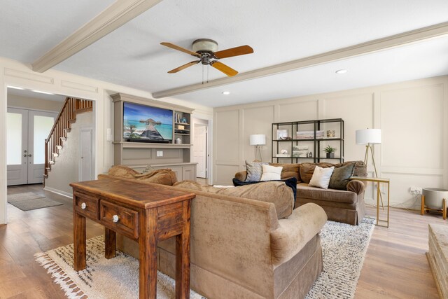 living room with beamed ceiling, ceiling fan, light hardwood / wood-style floors, and french doors