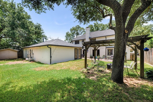 rear view of property featuring a pergola, a yard, and a patio