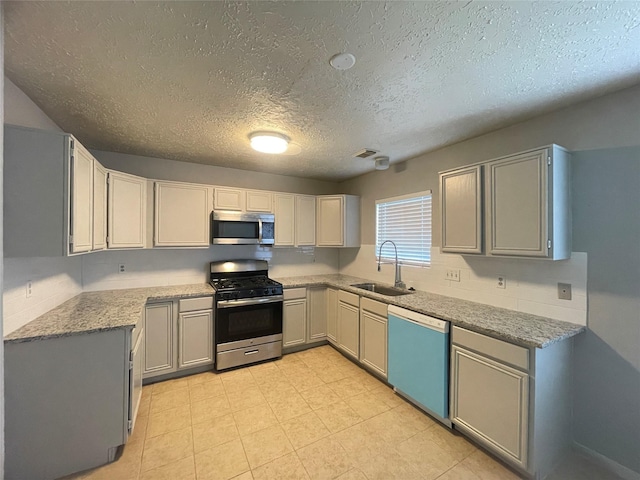 kitchen featuring a textured ceiling, gray cabinets, sink, and stainless steel appliances