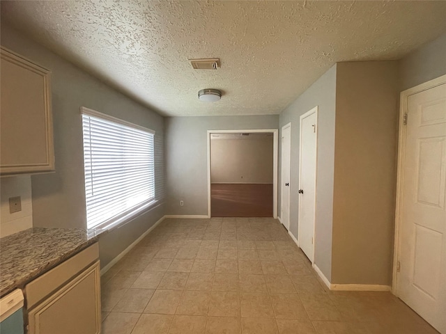 interior space featuring light tile patterned floors and a textured ceiling