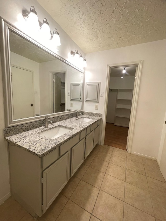 bathroom featuring tile patterned floors, vanity, and a textured ceiling