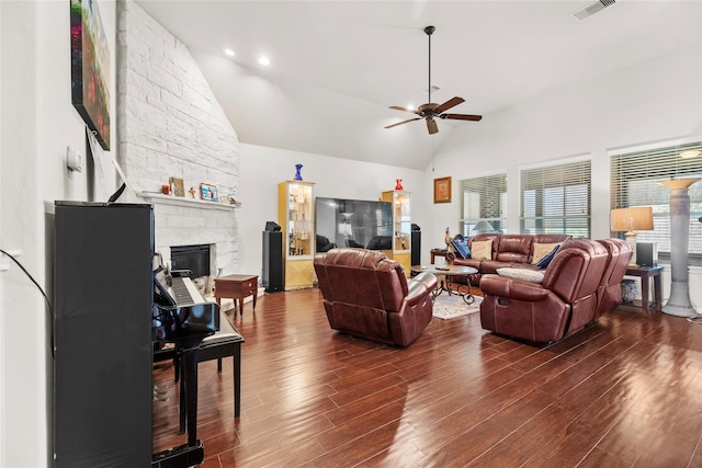 living room featuring ceiling fan, a stone fireplace, dark hardwood / wood-style flooring, and high vaulted ceiling