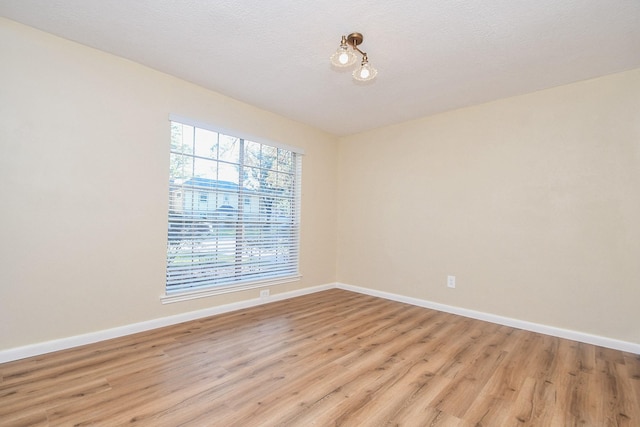 empty room featuring a textured ceiling and light wood-type flooring