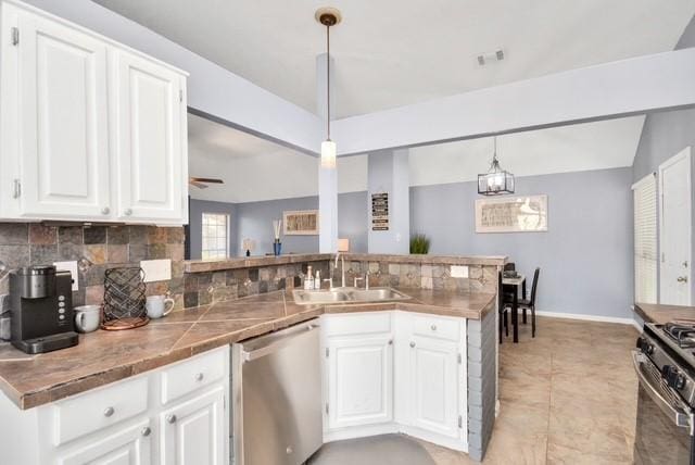 kitchen with appliances with stainless steel finishes, pendant lighting, kitchen peninsula, and sink