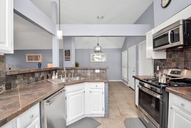 kitchen with white cabinetry, appliances with stainless steel finishes, tasteful backsplash, decorative light fixtures, and sink