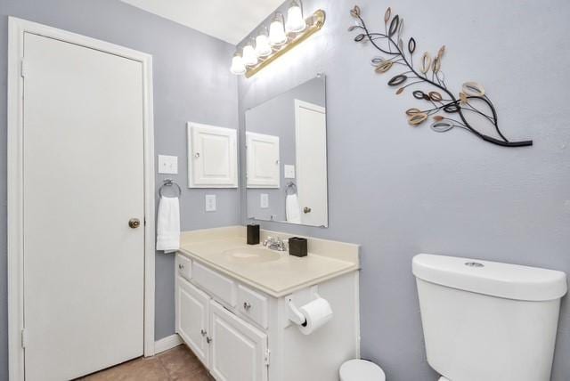 bathroom with toilet, tile patterned flooring, and vanity