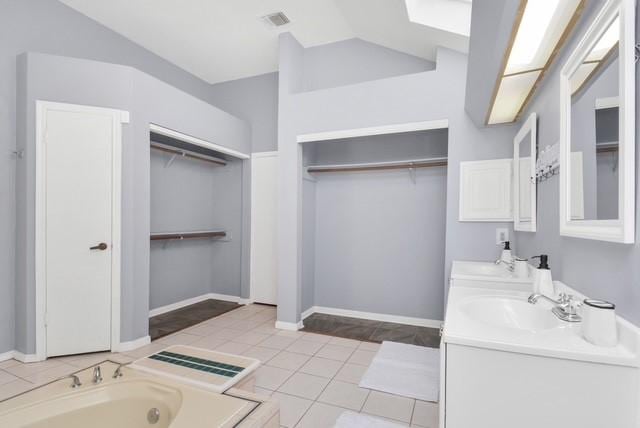 bathroom featuring a bathing tub, tile patterned floors, and vanity