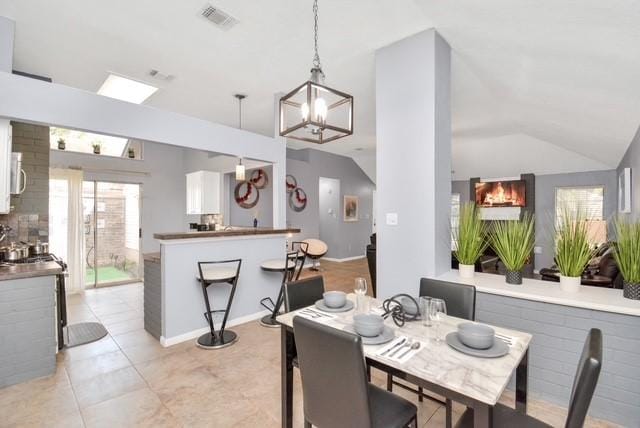 dining room featuring vaulted ceiling and a chandelier