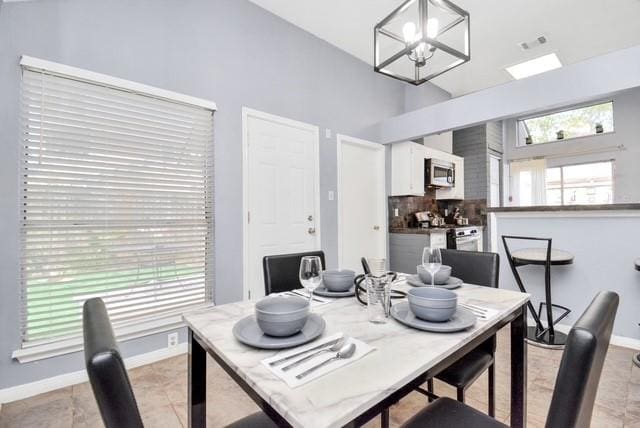 dining area featuring light tile patterned floors and a notable chandelier