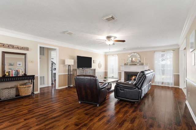 living room featuring crown molding, dark hardwood / wood-style flooring, ceiling fan, and a textured ceiling