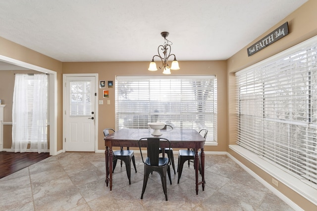 dining space with a chandelier, a textured ceiling, and light hardwood / wood-style floors