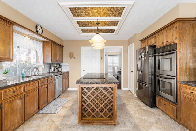 kitchen with a healthy amount of sunlight, sink, a kitchen island, and stainless steel appliances