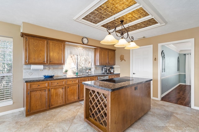 kitchen featuring decorative backsplash, sink, a kitchen island, and hanging light fixtures